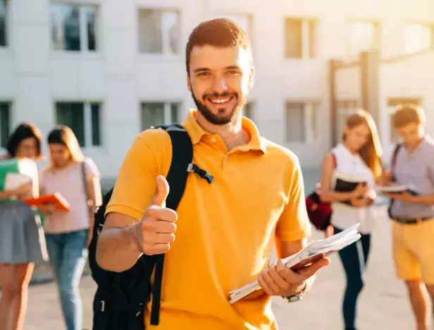 young-attractive-smiling-student-showing-thumb-up-outdoors-campus-university